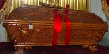 Carved wooden funerary urn with red ribbons